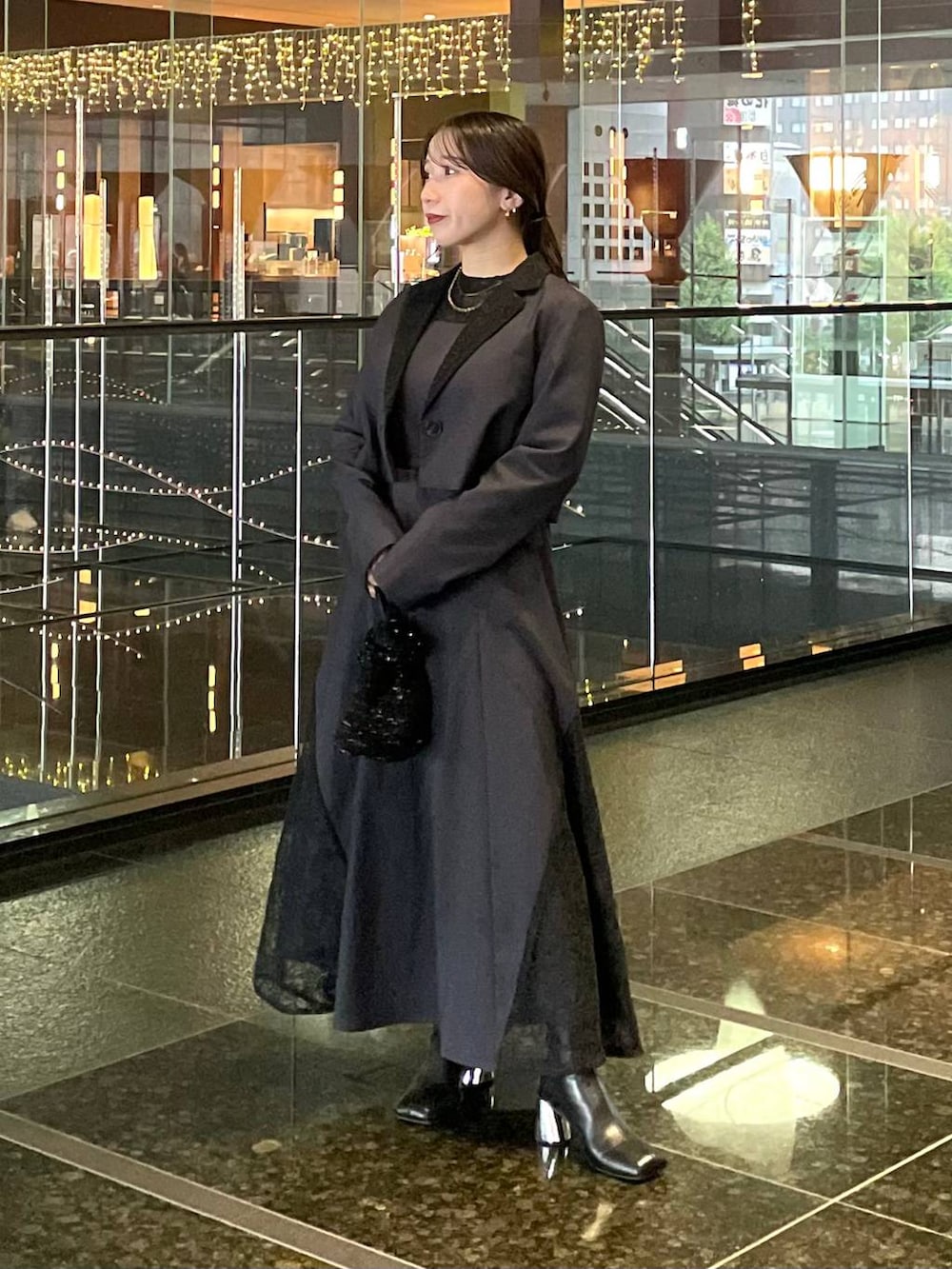 ブラック系のブーツ、グレー系のドレスを着用したレディースの秋コーディネートの2枚目の写真