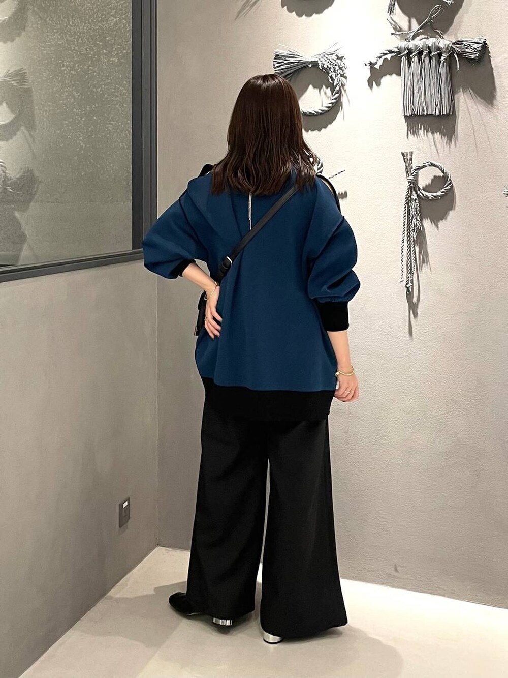 ブラック系のネクタイ、ブラック系のブーツ、ブラック系のショルダーバッグを着用したレディースの秋コーディネートの3枚目の写真