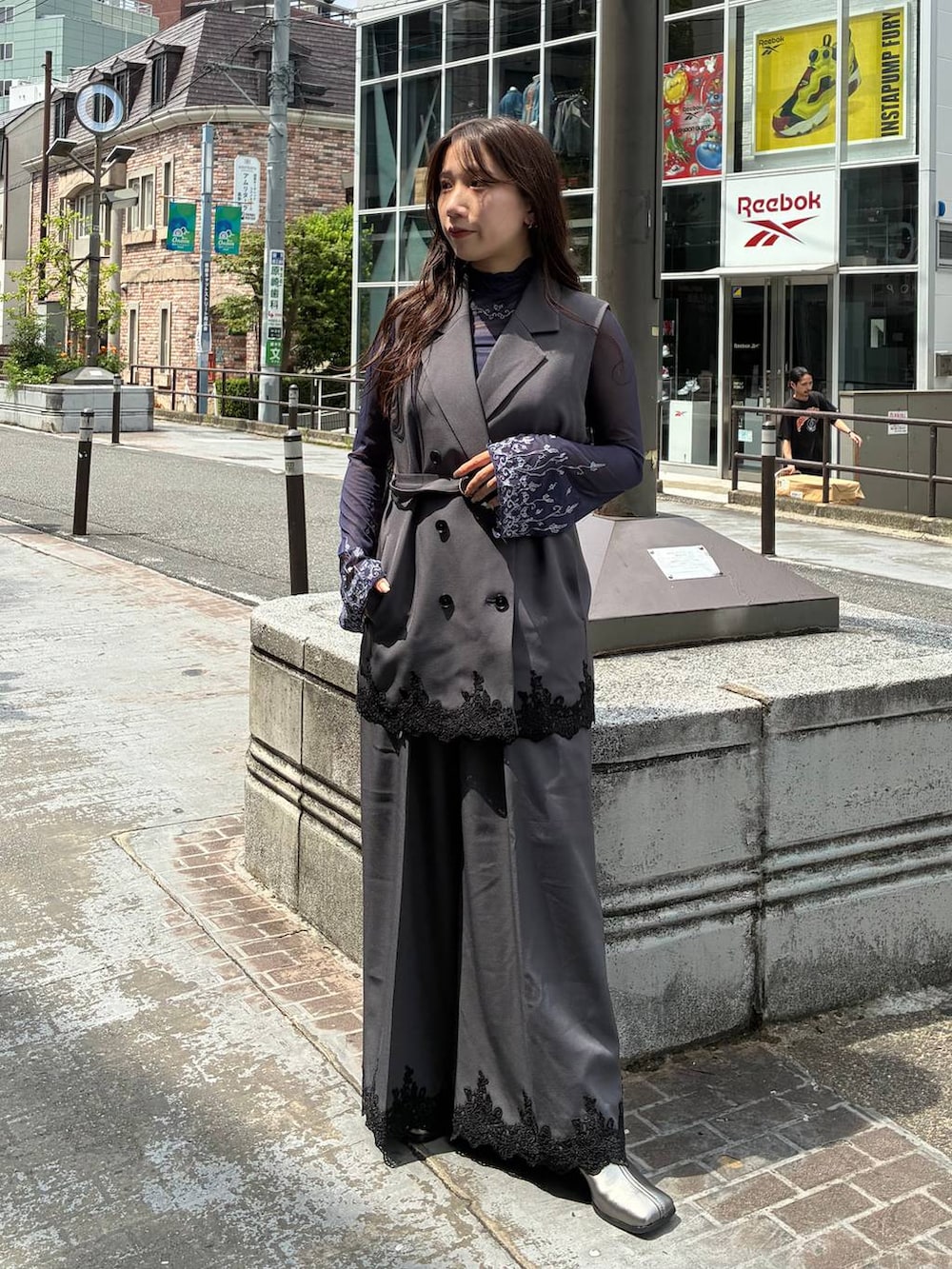 グレー系のスラックス、グレー系のテーラードジャケット、ブルー系のTシャツ/カットソーを着用したレディースの夏コーディネートの2枚目の写真