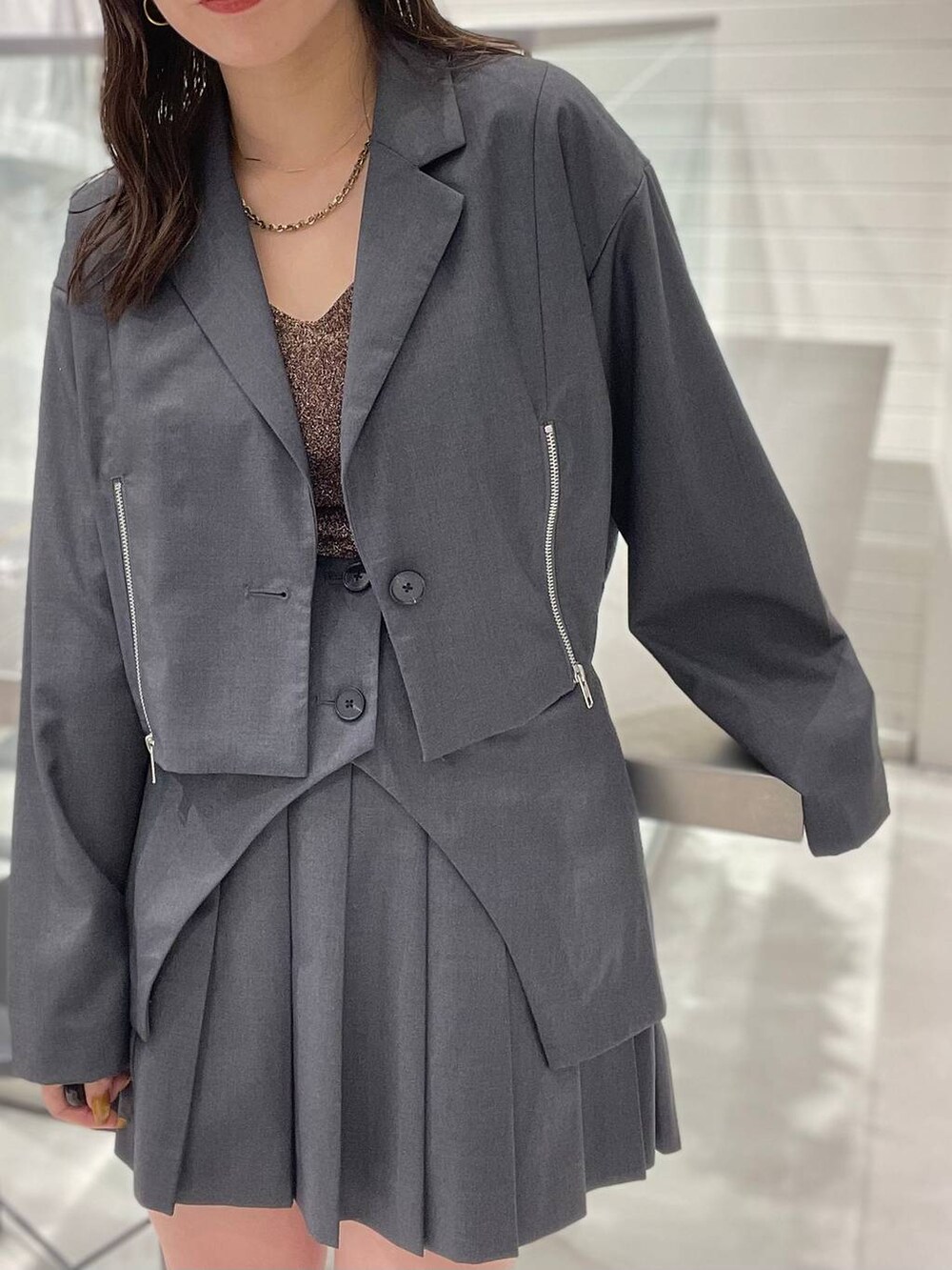 グレー系のテーラードジャケット、ブラック系のワンピース、ブラウン系のその他アンダーウェア/インナーを着用したレディースの夏コーディネートの2枚目の写真