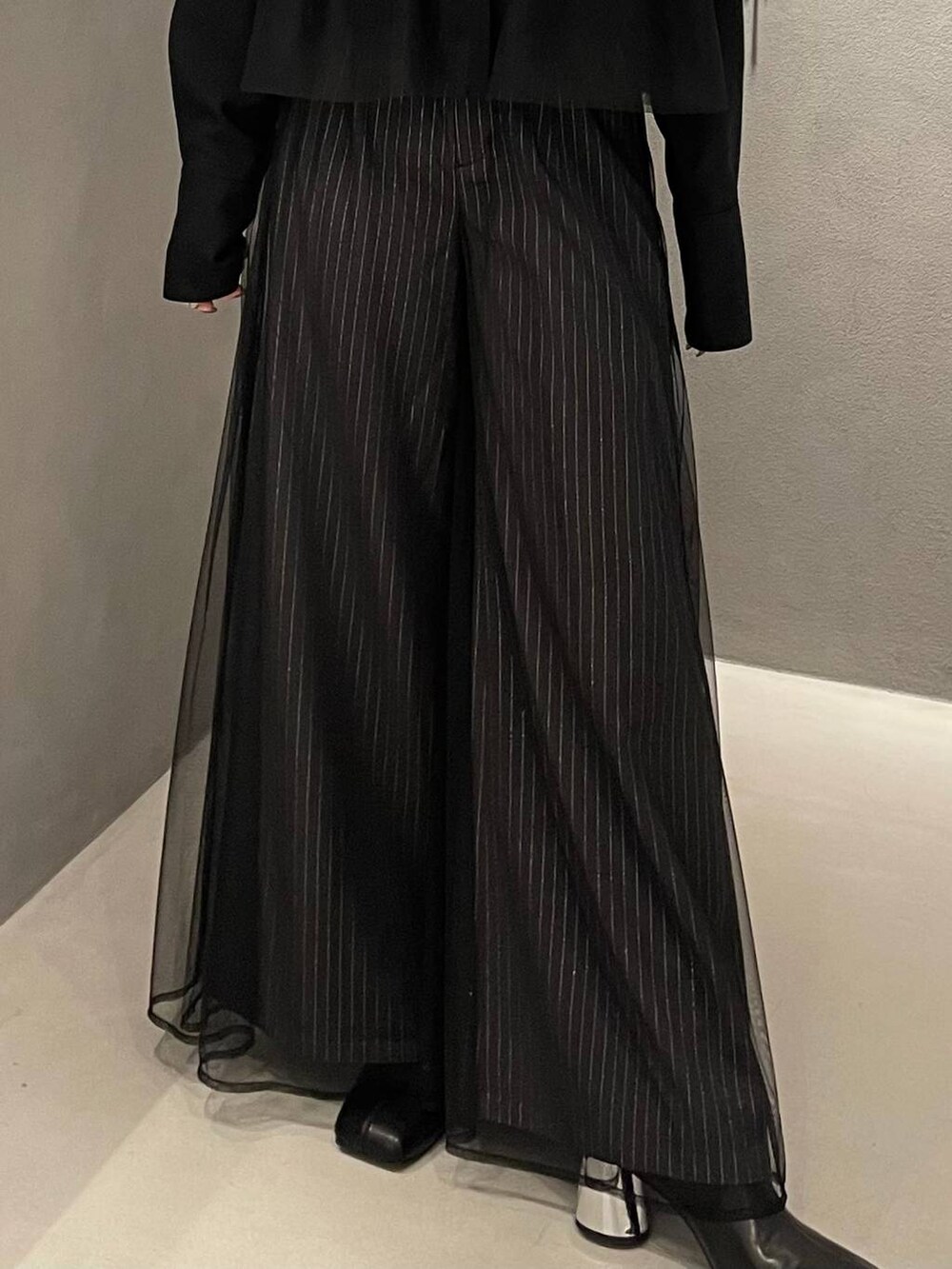 ブラック系のブーツ、ブラック系のシャツ/ブラウス、グレー系のその他パンツを着用したレディースの秋コーディネートの5枚目の写真