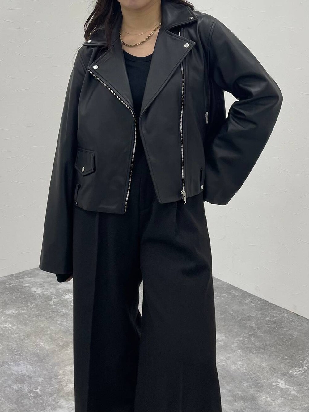 ブラック系のTシャツ/カットソー、ブラック系のライダースジャケット、ブラック系のスラックスを着用したレディースの秋コーディネートの4枚目の写真