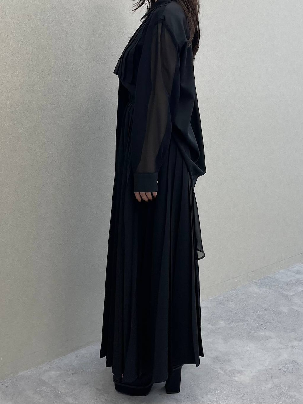 ブラック系のスカート、ブラック系のシャツ/ブラウス、ブラック系のサンダルを着用したレディースの春コーディネートの2枚目の写真