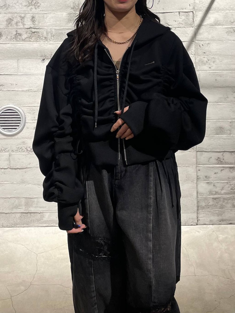 ブラック系のブーツ、ブラック系のデニムパンツ、ブラック系のパーカーを着用したレディースの冬コーディネートの4枚目の写真