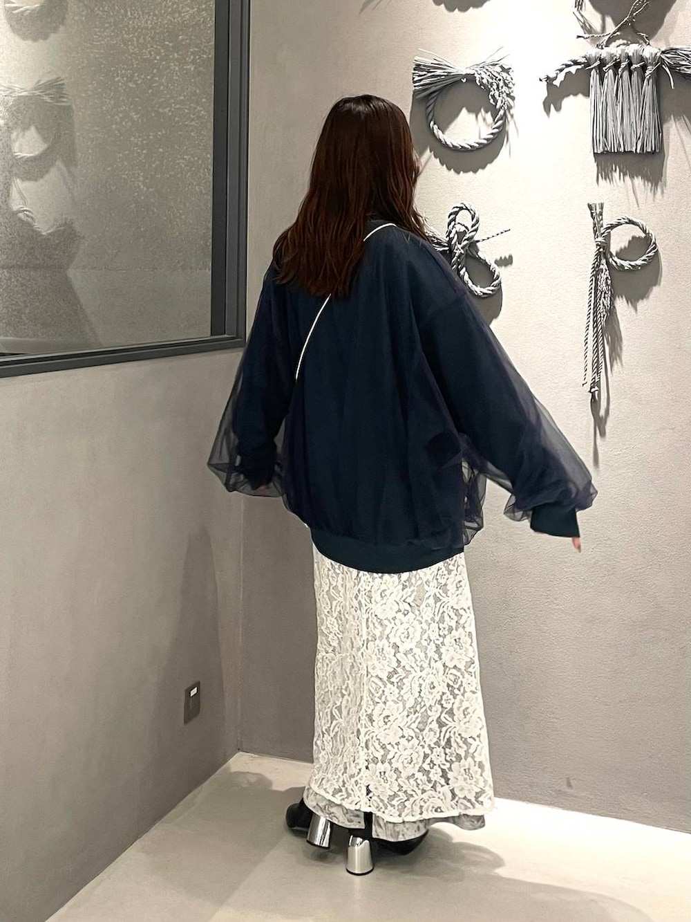 ブラック系のブーツ、グリーン系のスウェット、グレー系のスカートを着用したレディースの秋コーディネートの2枚目の写真