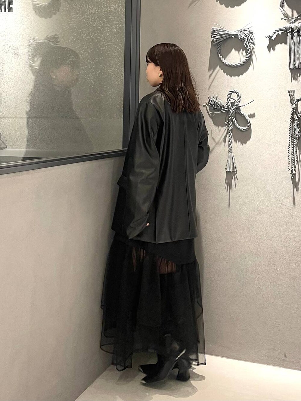 ブラック系のブーツ、ブラック系のテーラードジャケット、ブラック系のTシャツ/カットソーを着用したレディースの秋コーディネートの2枚目の写真