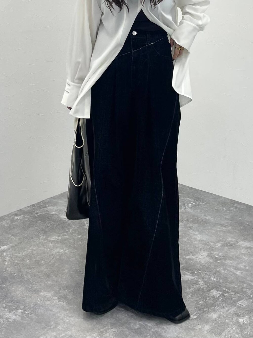 ブラック系のブーツ、ブラック系のショルダーバッグ、ホワイト系のシャツ/ブラウスを着用したレディースの秋コーディネートの6枚目の写真