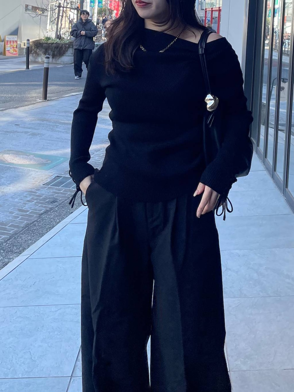 ブラック系のスラックス、ブラック系のニット/セーターを着用したレディースの冬コーディネートの3枚目の写真