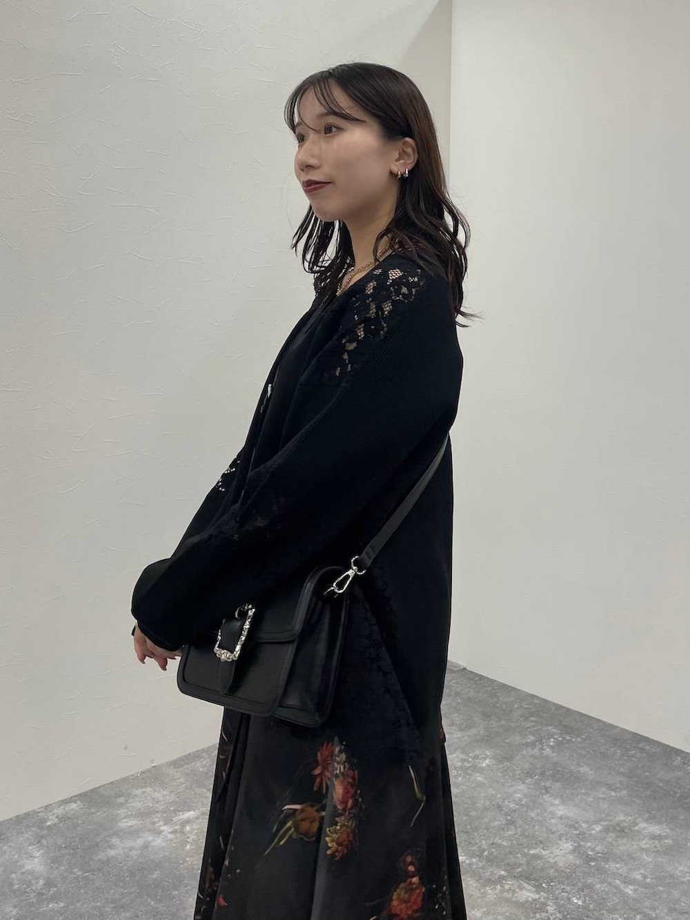 ブラック系のショルダーバッグ、ブラック系のカーディガン/ボレロ、ブラック系のブーツを着用したレディースの秋コーディネートの5枚目の写真