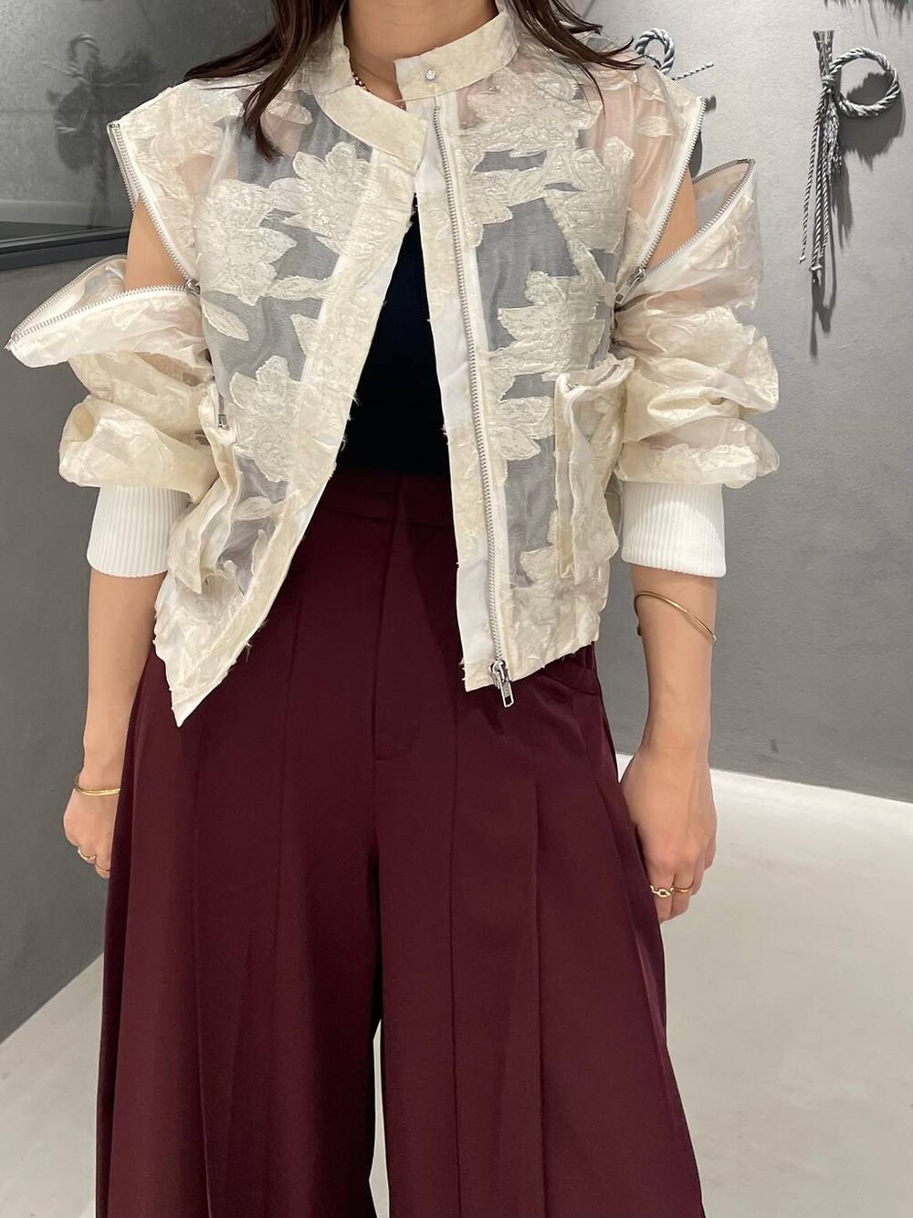 ブラック系のタンクトップ、ブラック系のパンプス、ホワイト系のブルゾンを着用したレディースの夏コーディネートの4枚目の写真