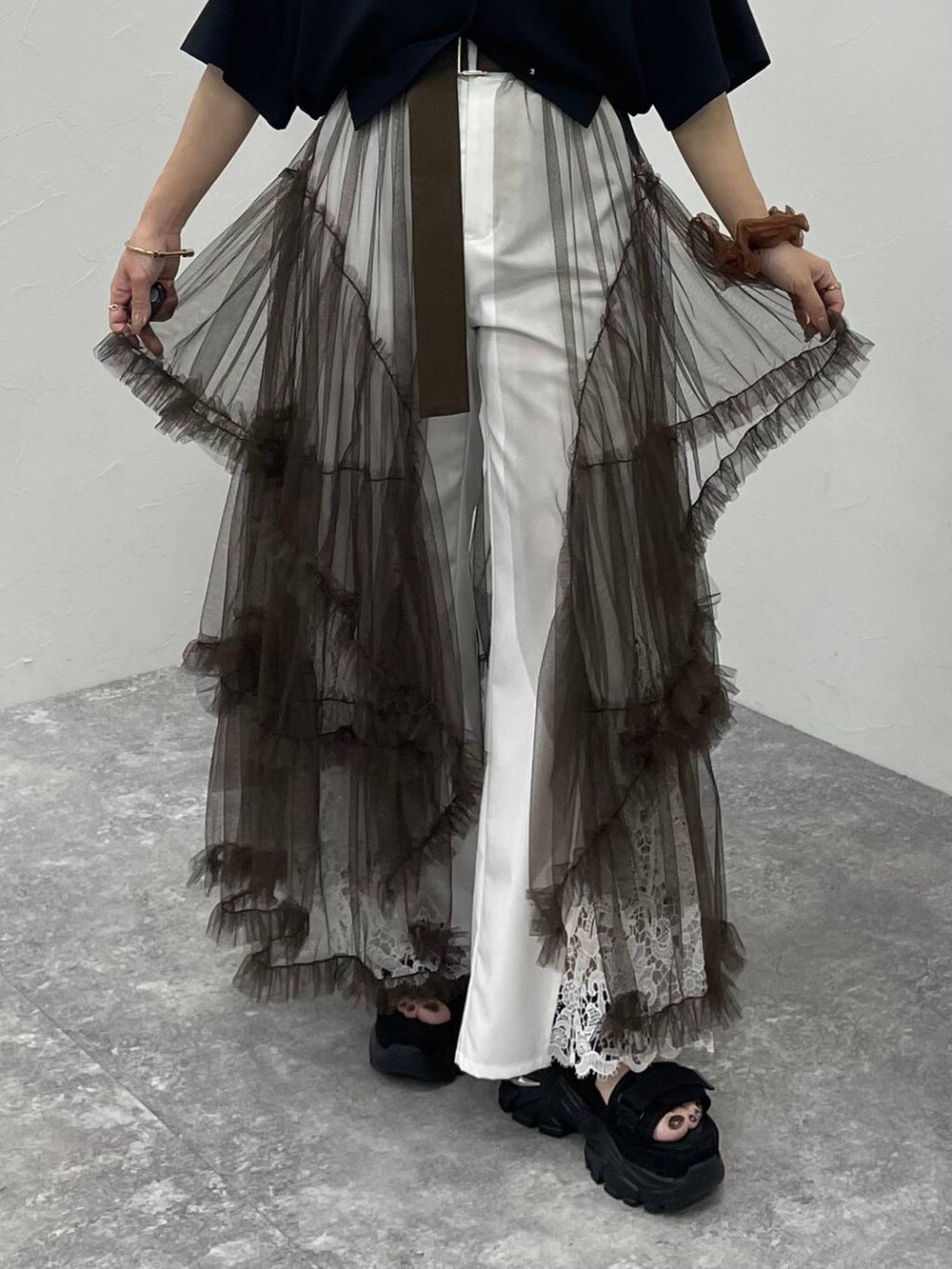 ブラウン系のスカート、ブラック系のサンダル、ホワイト系のその他パンツを着用したレディースの夏コーディネートの5枚目の写真