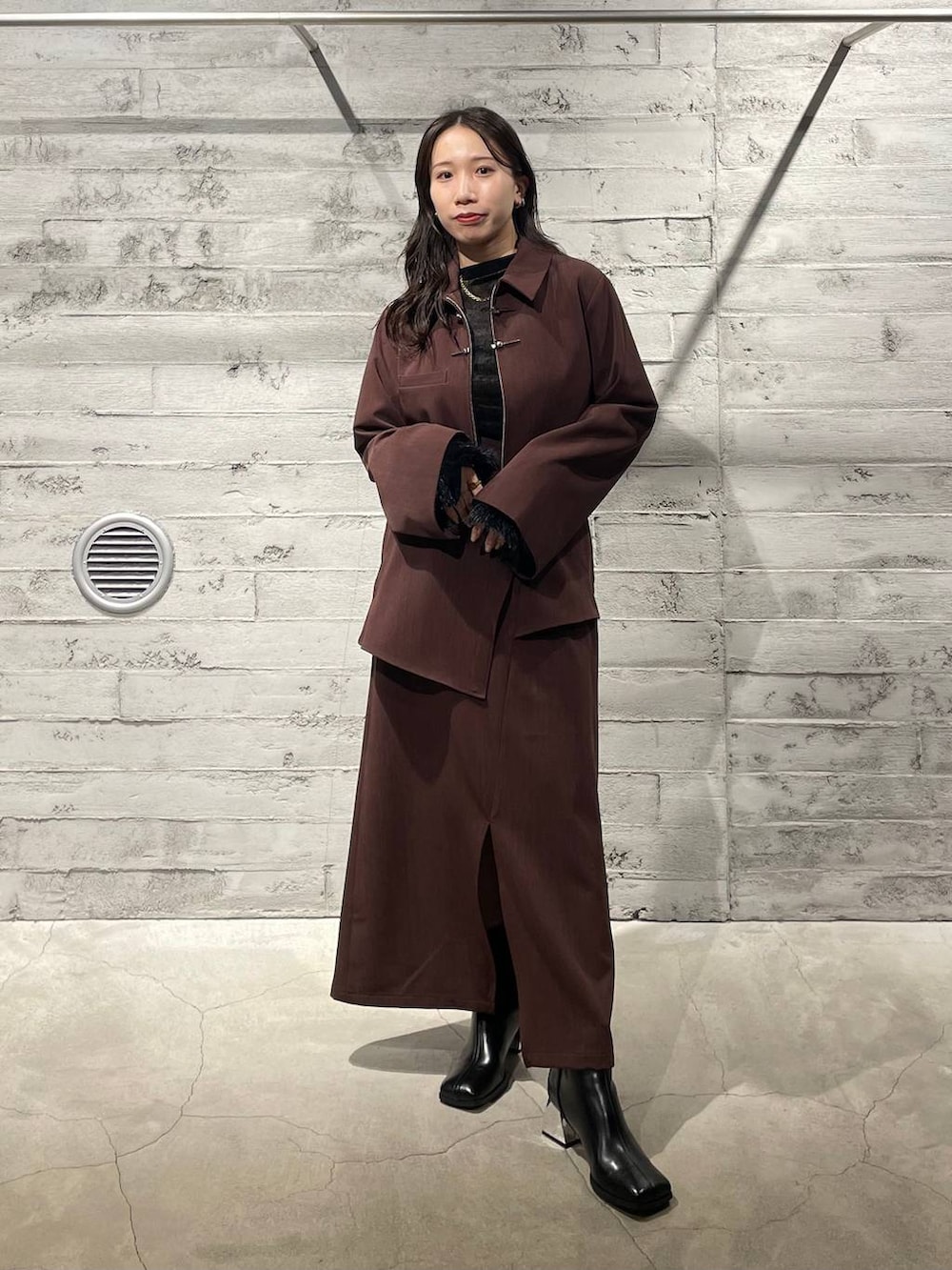 ブラック系のブーツ、ブラック系のTシャツ/カットソー、レッド系のスカートを着用したレディースの冬コーディネートの2枚目の写真