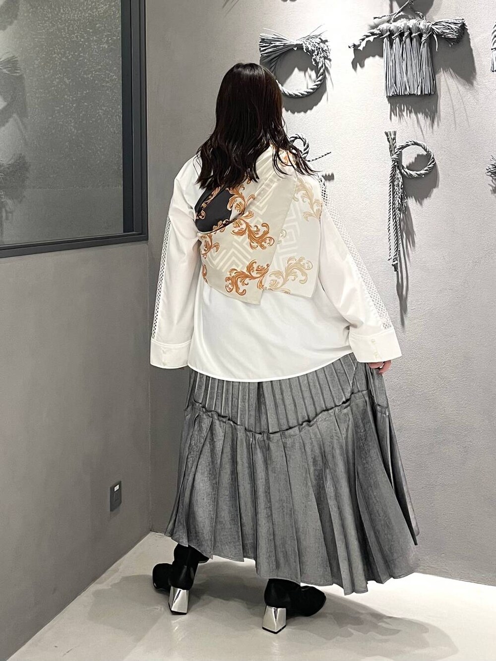 ブラック系のブーツ、ホワイト系のシャツ/ブラウス、シルバー系のスカートを着用したレディースの春コーディネートの2枚目の写真