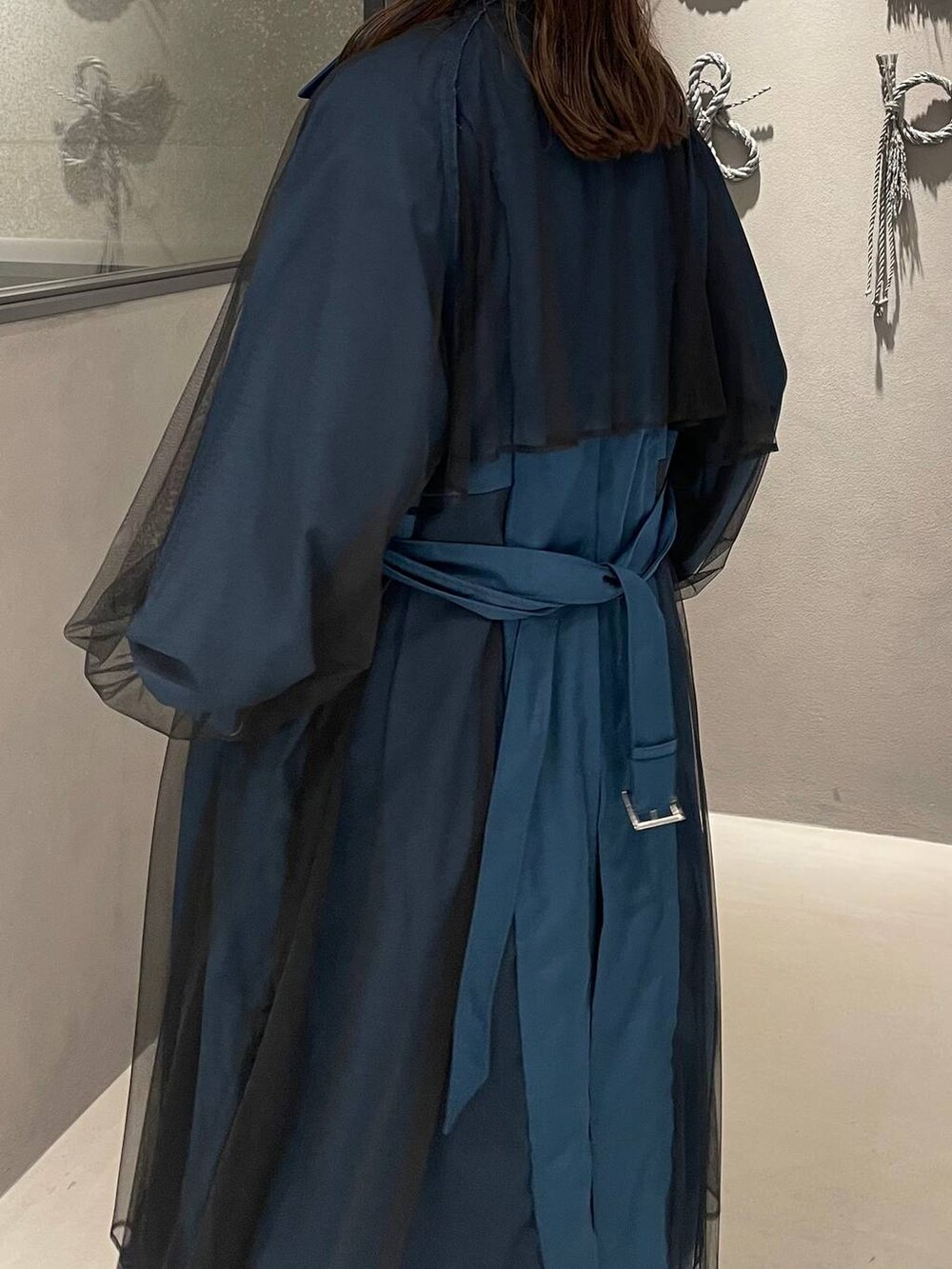 ブラック系のスカート、ブラック系のパンプス、ブルー系のトレンチコートを着用したレディースの秋コーディネートの5枚目の写真