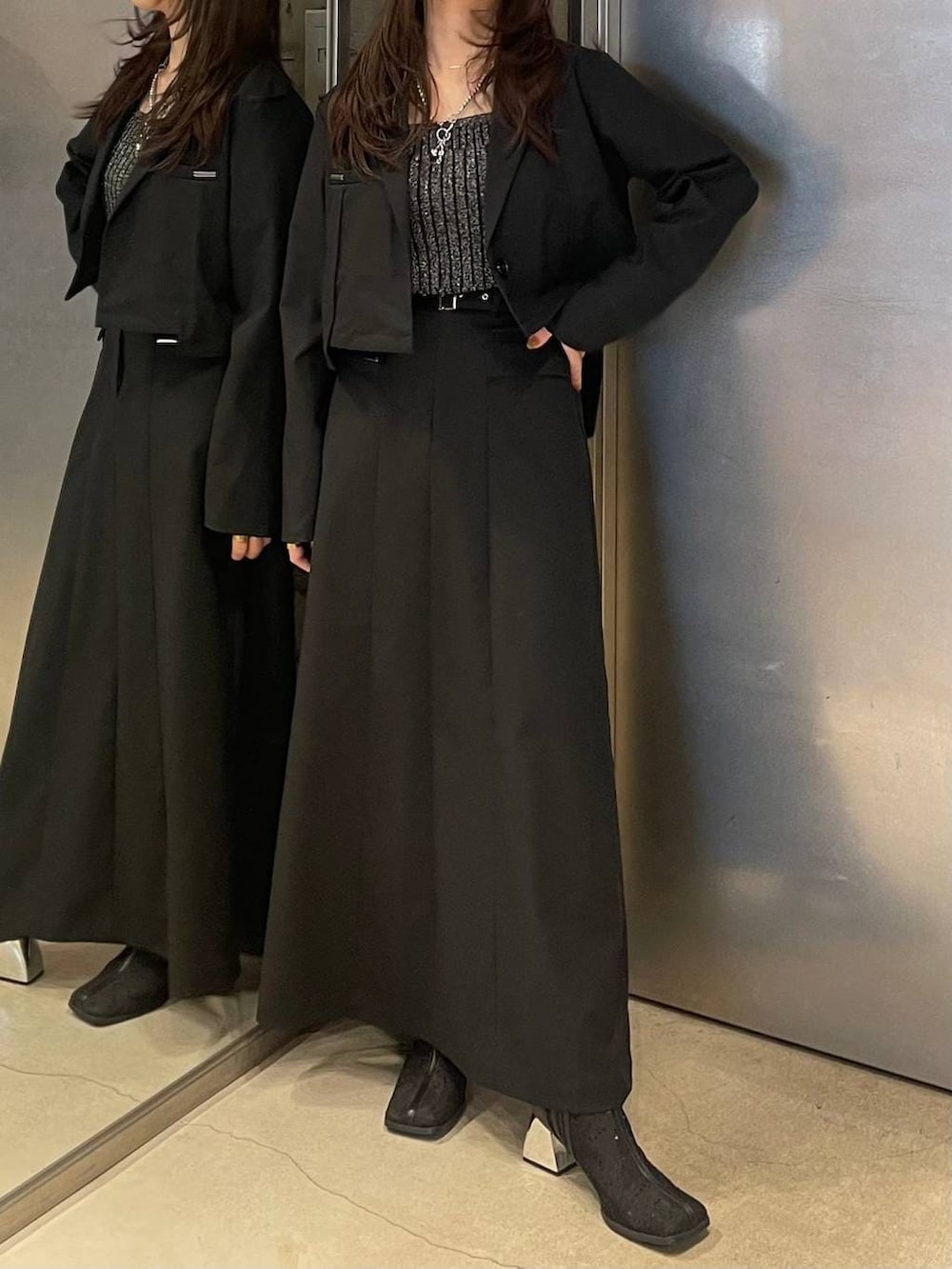 ブラック系のブーツ、ブラック系のタンクトップ、ブラック系のテーラードジャケットを着用したレディースの春コーディネートの4枚目の写真