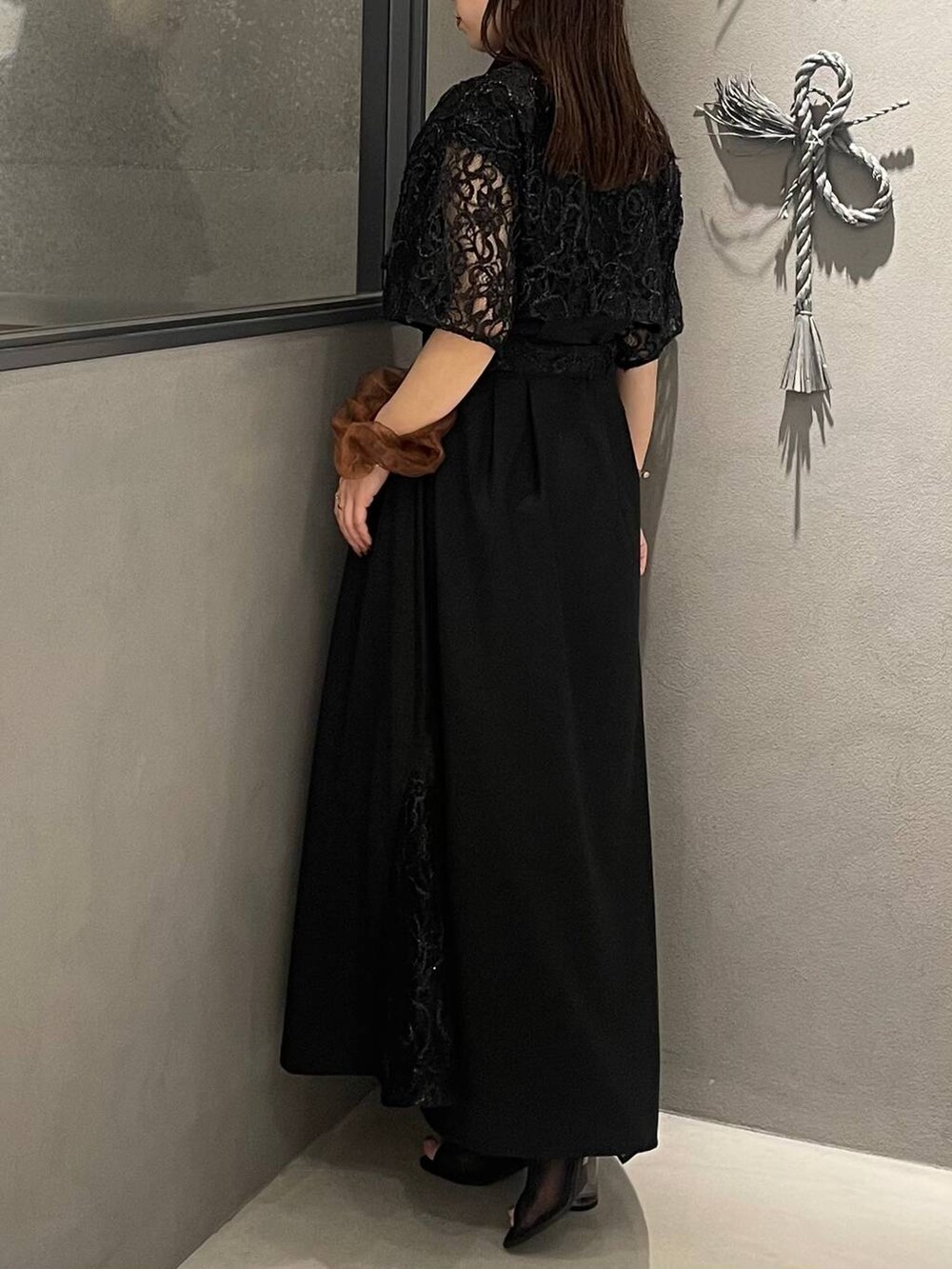 ブラック系のサンダル、ブラック系のワンピースを着用したレディースの夏コーディネートの3枚目の写真