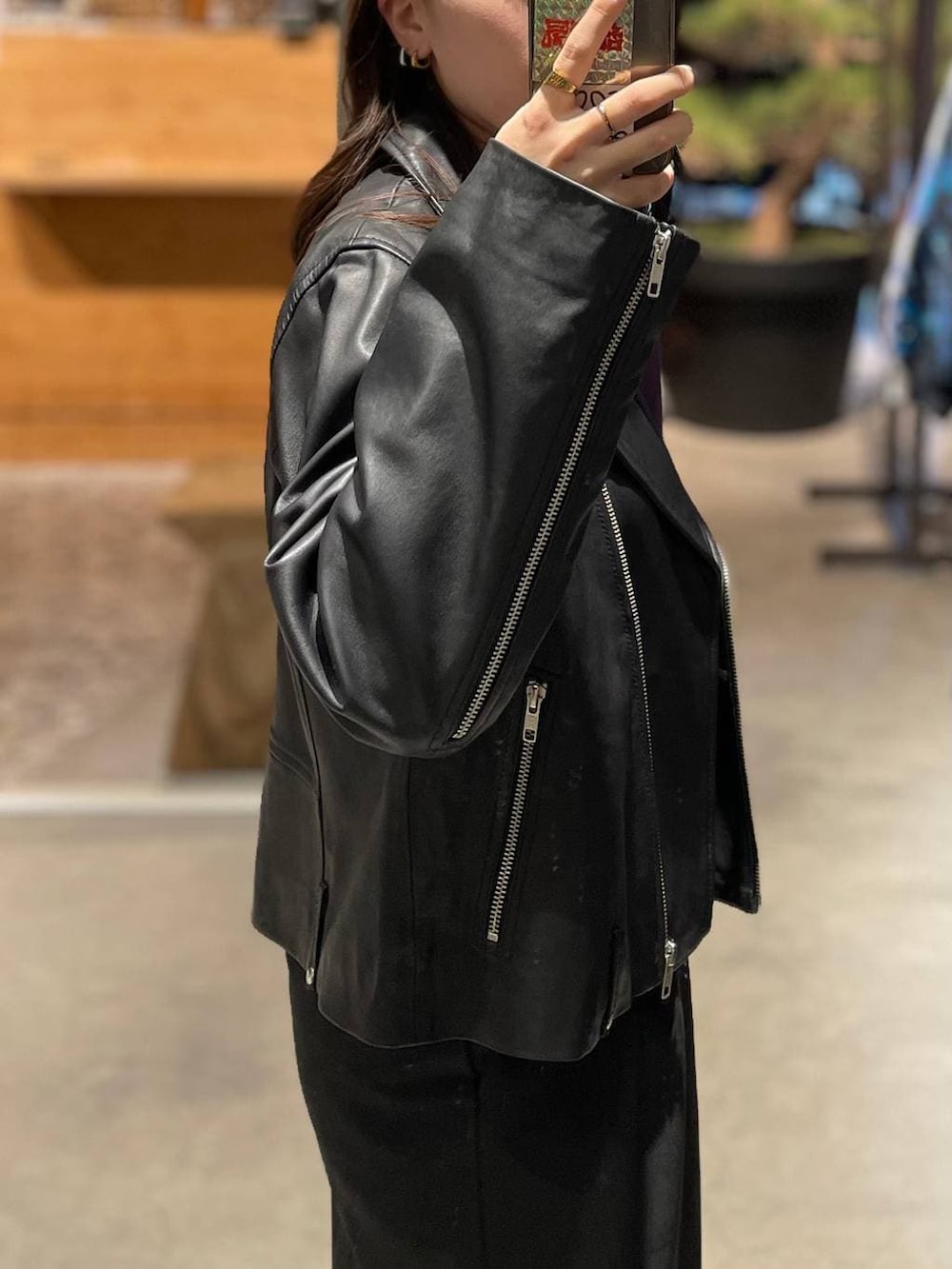 ブラック系のライダースジャケット、ブラック系のスラックスを着用したレディースの秋コーディネートの3枚目の写真