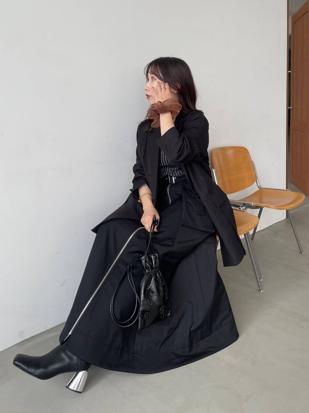 ブラック系のタンクトップ、ブラック系のショルダーバッグ、ブラック系のブーツを着用したレディースの夏コーディネートの7枚目の写真