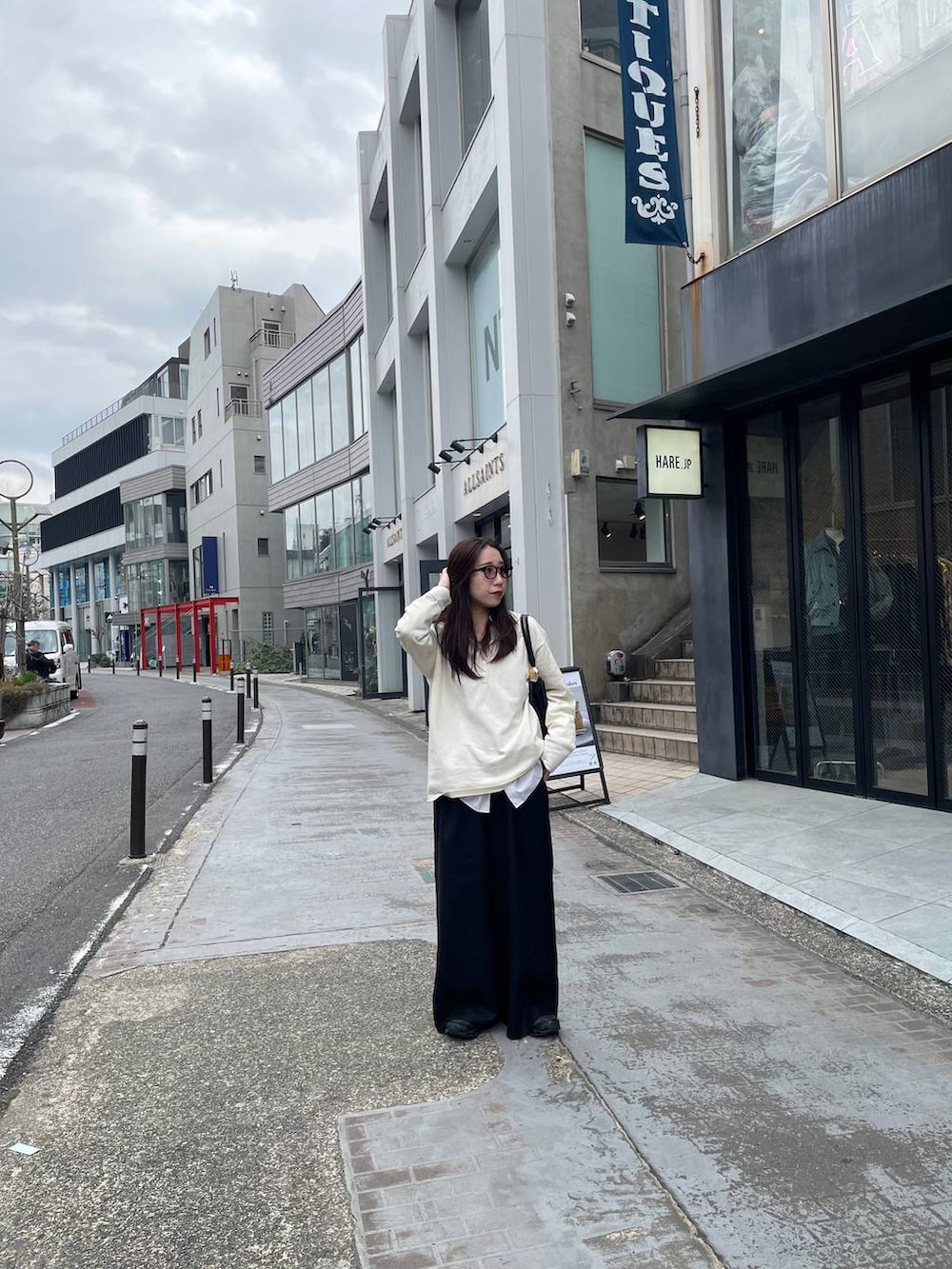 ブラック系のスラックスを着用したレディースの春コーディネートの3枚目の写真