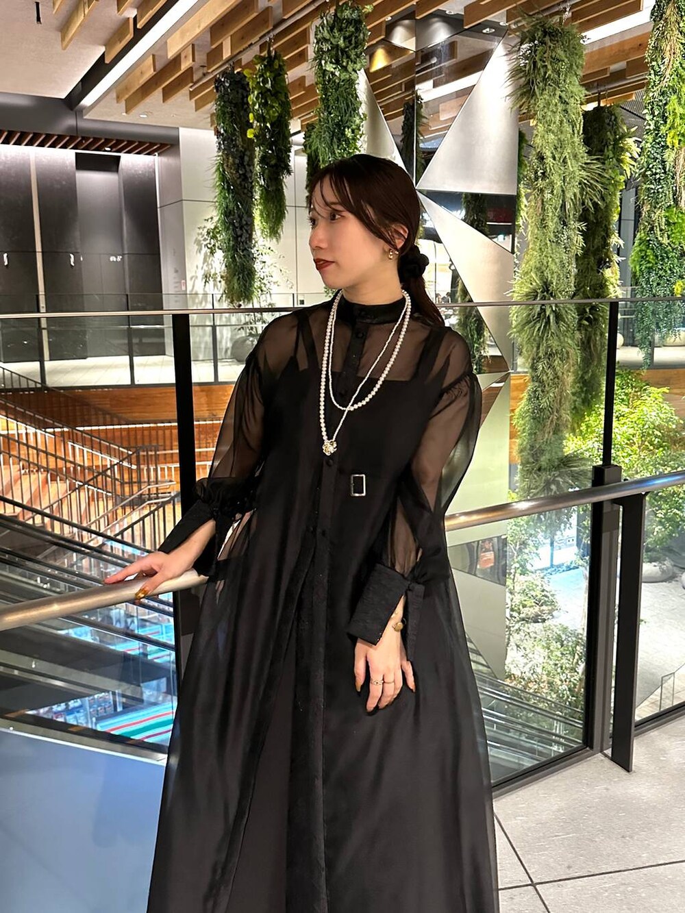 ブラック系のブーツ、ブラック系のドレス、ゴールド系のネックレスを着用したレディースの夏コーディネートの5枚目の写真