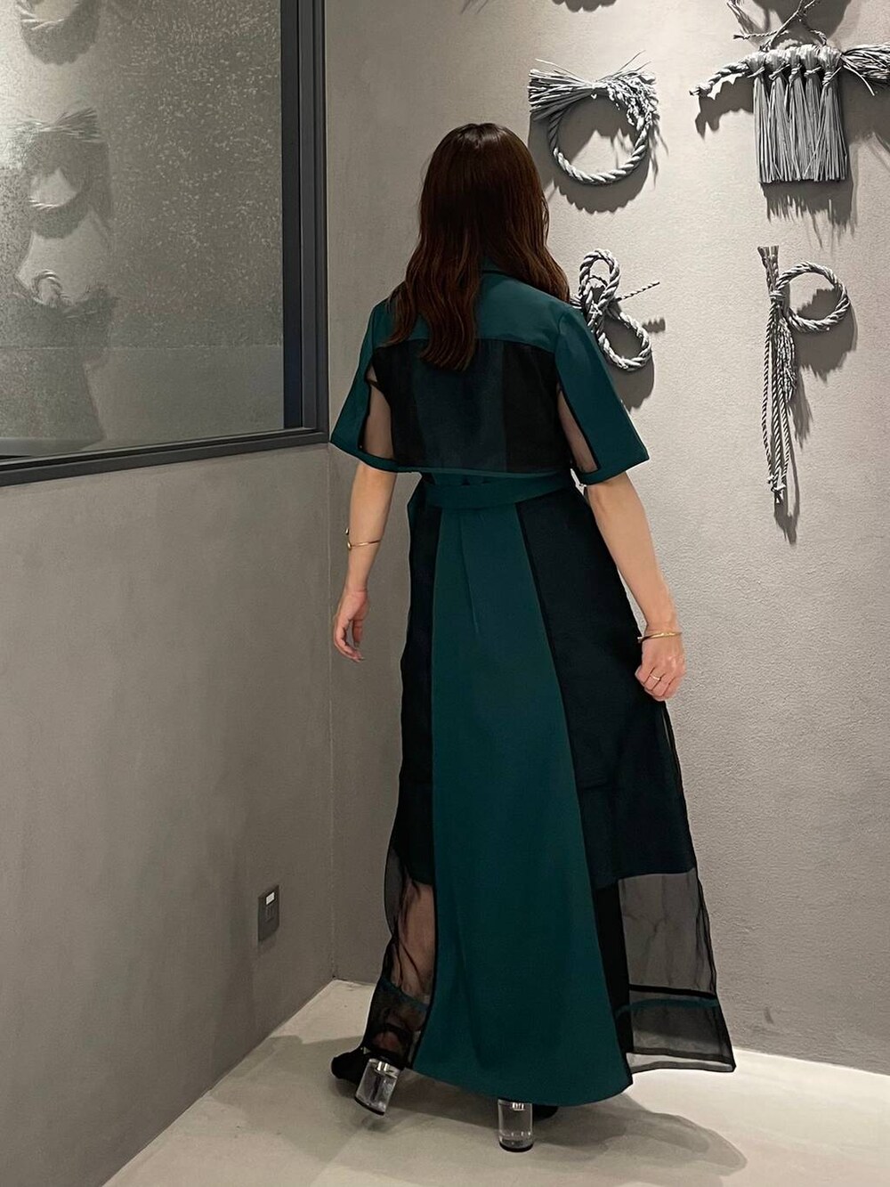 ブラック系のサンダル、グリーン系のワンピースを着用したレディースの夏コーディネートの2枚目の写真