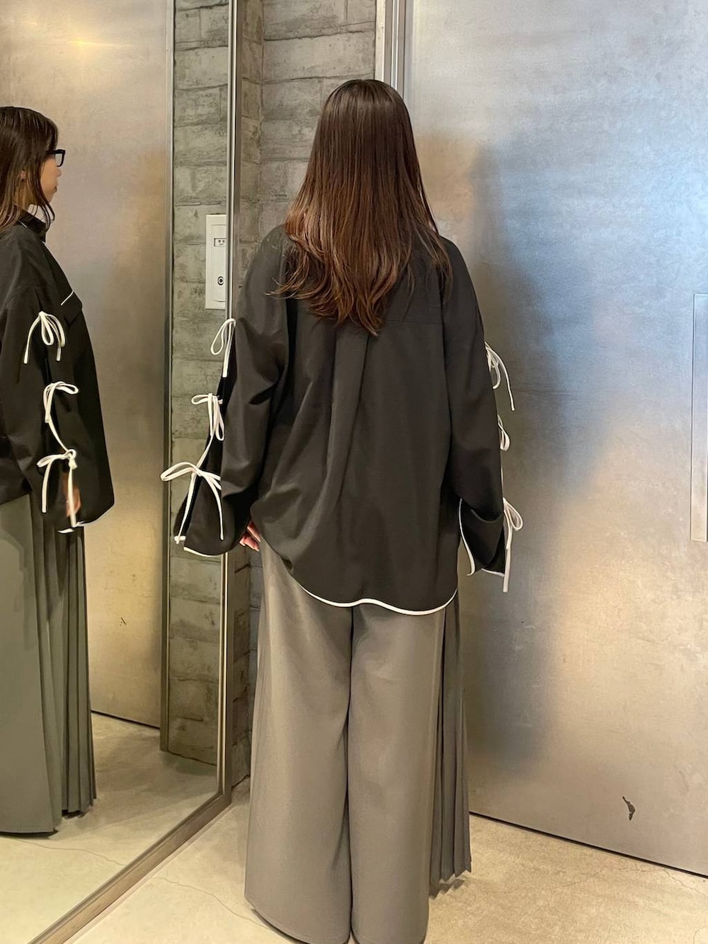 ブラック系のサンダル、グレー系のスラックス、ブラック系のシャツ/ブラウスを着用したレディースの春コーディネートの4枚目の写真