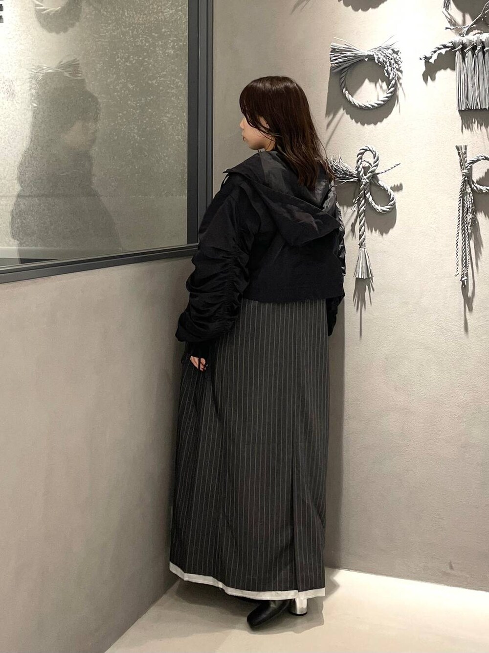 ホワイト系のタンクトップ、グレー系のワンピース、ブラック系のブーツを着用したレディースの秋コーディネートの3枚目の写真