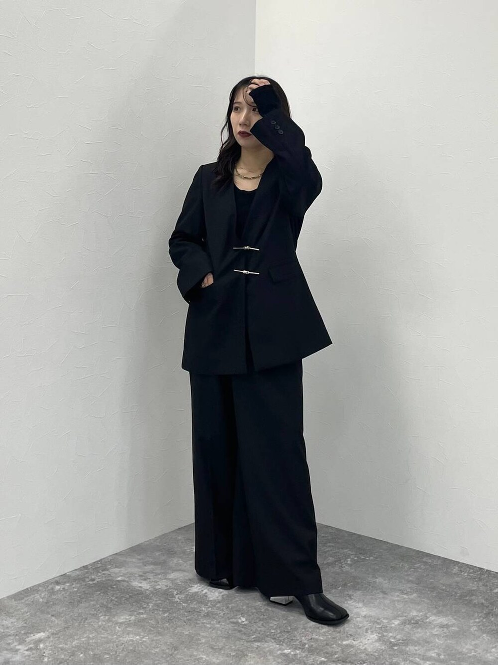 ブラック系のブーツ、ブラック系のノーカラージャケット、ブラック系のスラックスを着用したレディースの秋コーディネートの2枚目の写真