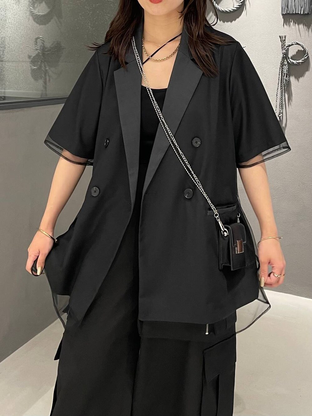 ブラック系のショルダーバッグ、ブラック系のパンプス、ブラック系のカーゴパンツを着用したレディースの夏コーディネートの4枚目の写真