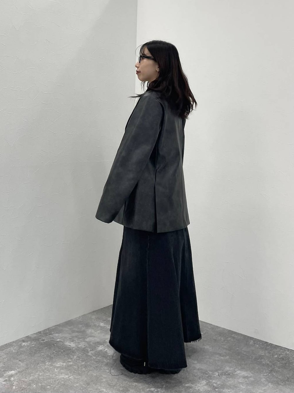 ブラック系のTシャツ/カットソー、ブラック系のスニーカー、グレー系のテーラードジャケットを着用したレディースの秋コーディネートの2枚目の写真