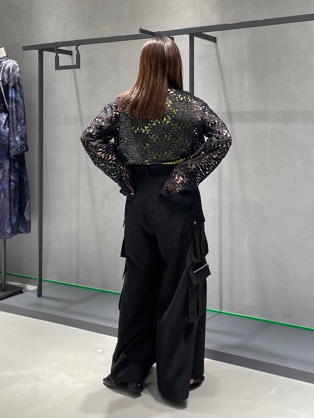 ブラック系のカーゴパンツ、ブラック系のサンダル、イエロー系のタンクトップを着用したレディースの春コーディネートの3枚目の写真