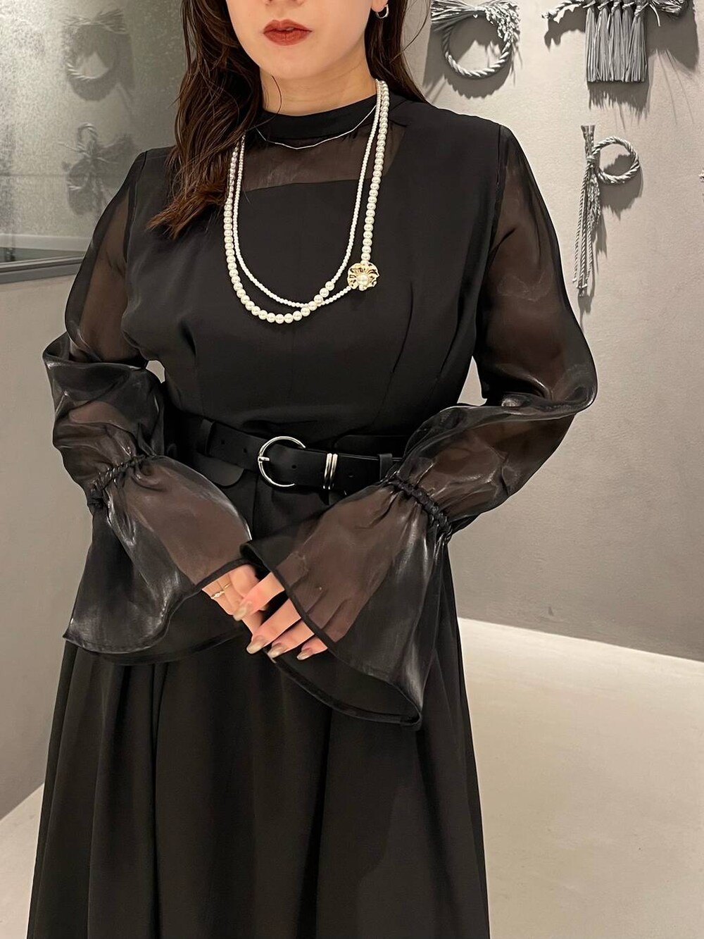 ブラック系のパンプス、ブラック系のベルト、ゴールド系のネックレスを着用したレディースの秋コーディネートの5枚目の写真