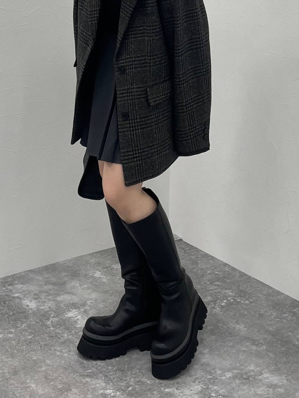 ブラック系のTシャツ/カットソー、ブラック系のショルダーバッグ、ブラック系のブーツを着用したレディースの秋コーディネートの5枚目の写真