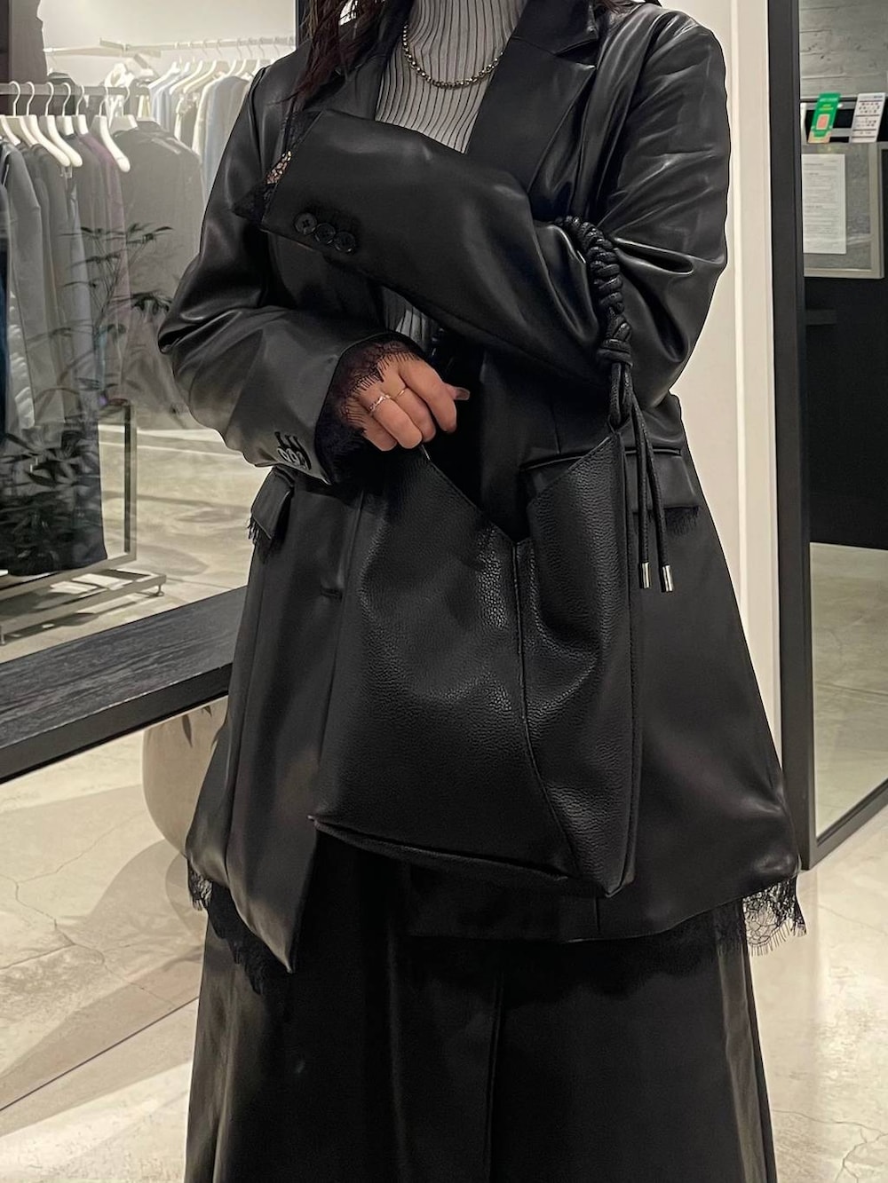 グレー系のニット/セーター、ブラック系のスカート、ブラック系のテーラードジャケットを着用したレディースの秋コーディネートの5枚目の写真