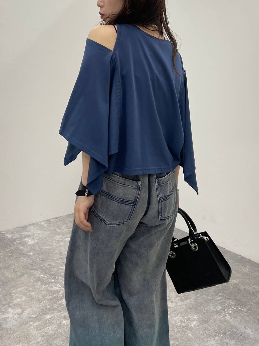 ブルー系のデニムパンツ、ブラック系のショルダーバッグ、ブラック系のサンダルを着用したレディースの夏コーディネートの7枚目の写真