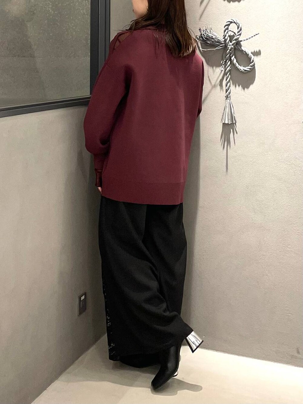 ブラック系のショルダーバッグ、ブラック系のブーツ、レッド系のTシャツ/カットソーを着用したレディースの秋コーディネートの3枚目の写真