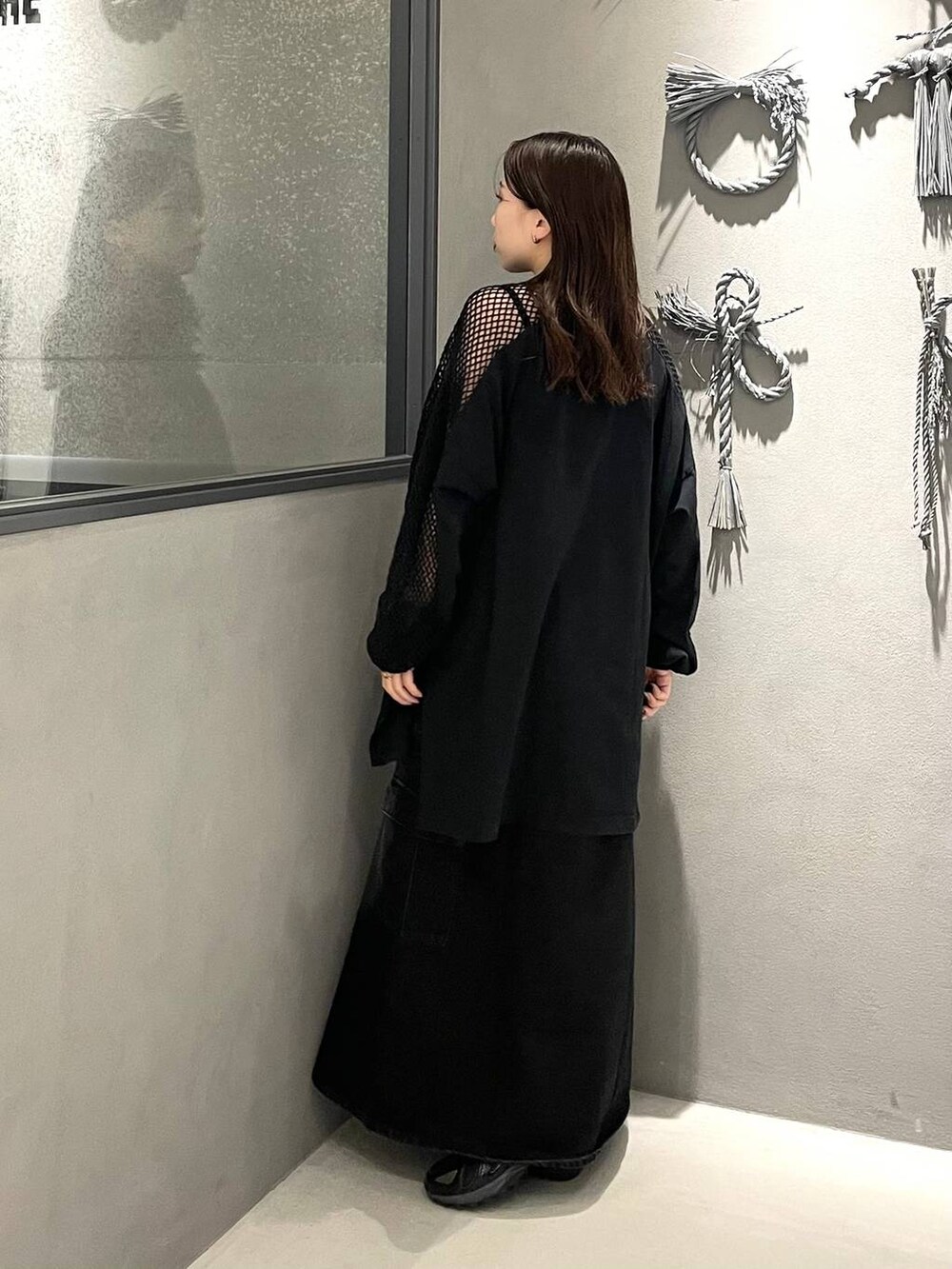 ブラック系のTシャツ/カットソー、ブラック系のデニムスカートを着用したレディースの春コーディネートの2枚目の写真