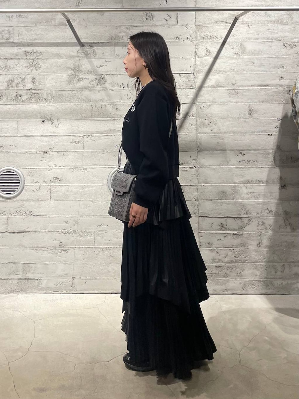 ブラック系のスウェット、グレー系のショルダーバッグ、ブラック系のスカートを着用したレディースの冬コーディネートの3枚目の写真