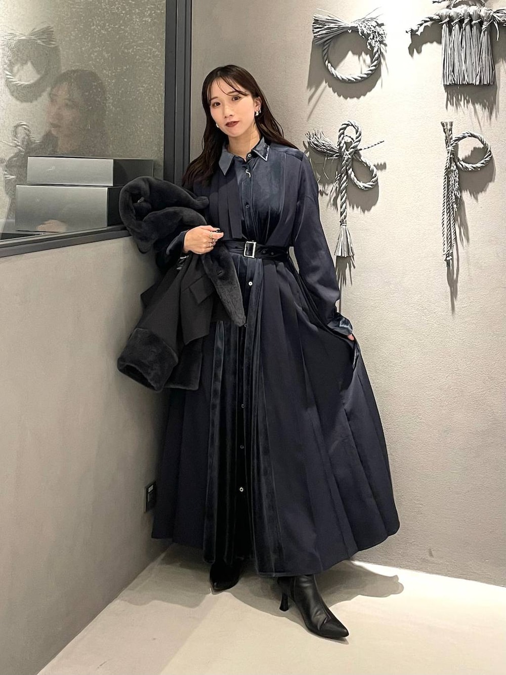 ブルー系のワンピース、ブラック系のブーツ、グレー系のその他アウターを着用したレディースの冬コーディネートの2枚目の写真