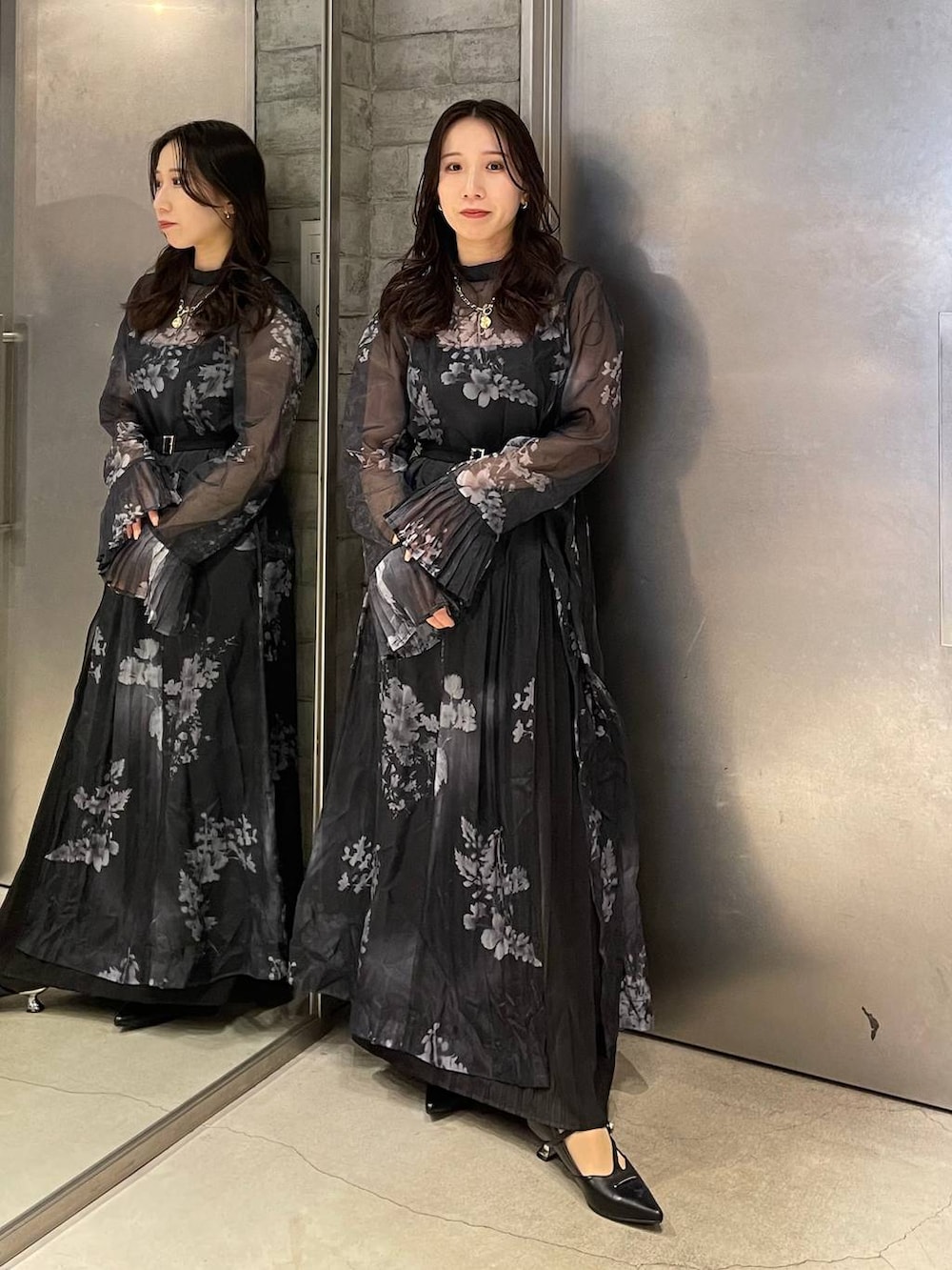 ブラック系のパンプス、ブラック系のワンピース、ゴールド系のネックレスを着用したレディースの冬コーディネートの2枚目の写真