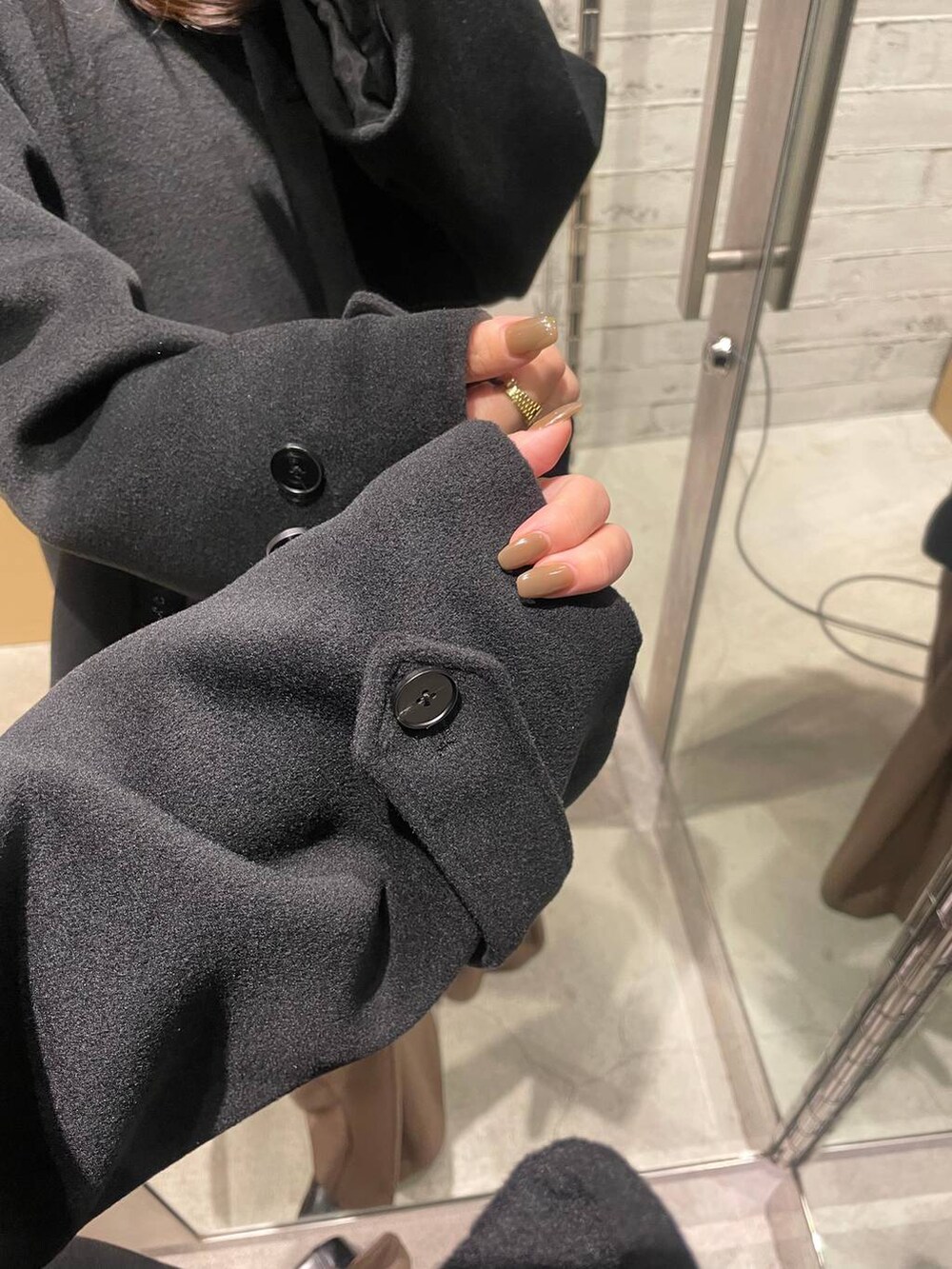 ブラック系のノーカラーコート、ブラウン系のその他パンツ、ブラック系のTシャツ/カットソーを着用したレディースの冬コーディネートの7枚目の写真