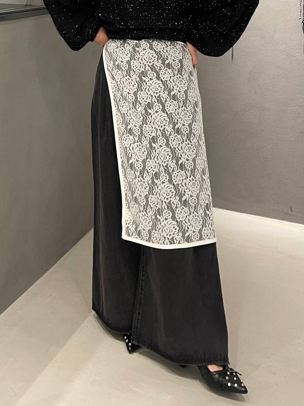 ブラック系のパンプス、ブラック系のニット/セーター、ブラック系のデニムパンツを着用したレディースの秋コーディネートの5枚目の写真