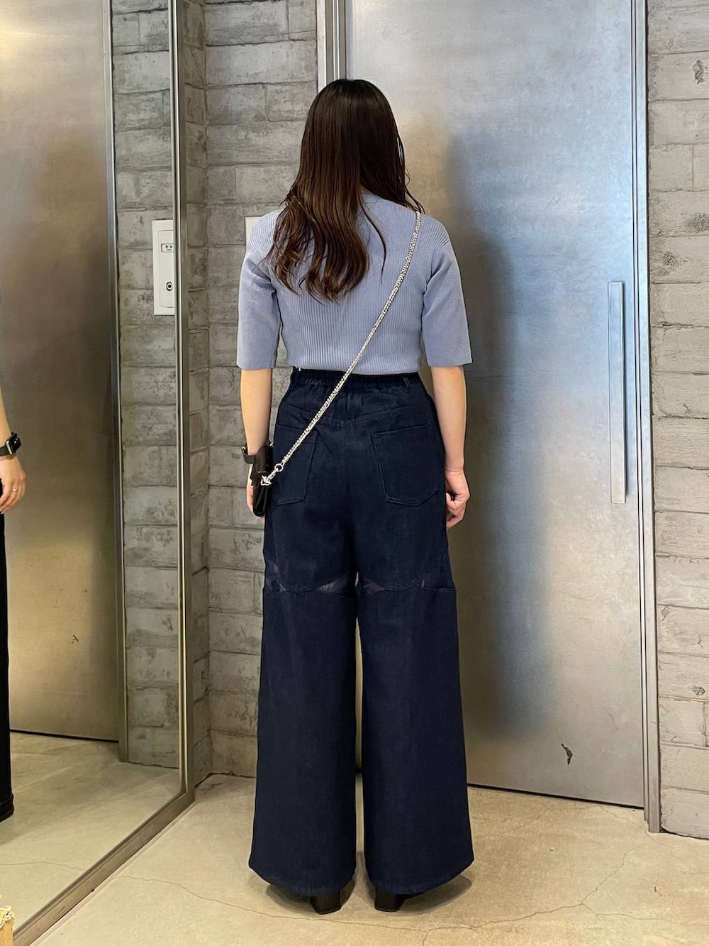 シルバー系のブーツ、ブルー系のデニムパンツ、ブルー系のニット/セーターを着用したレディースの春コーディネートの3枚目の写真