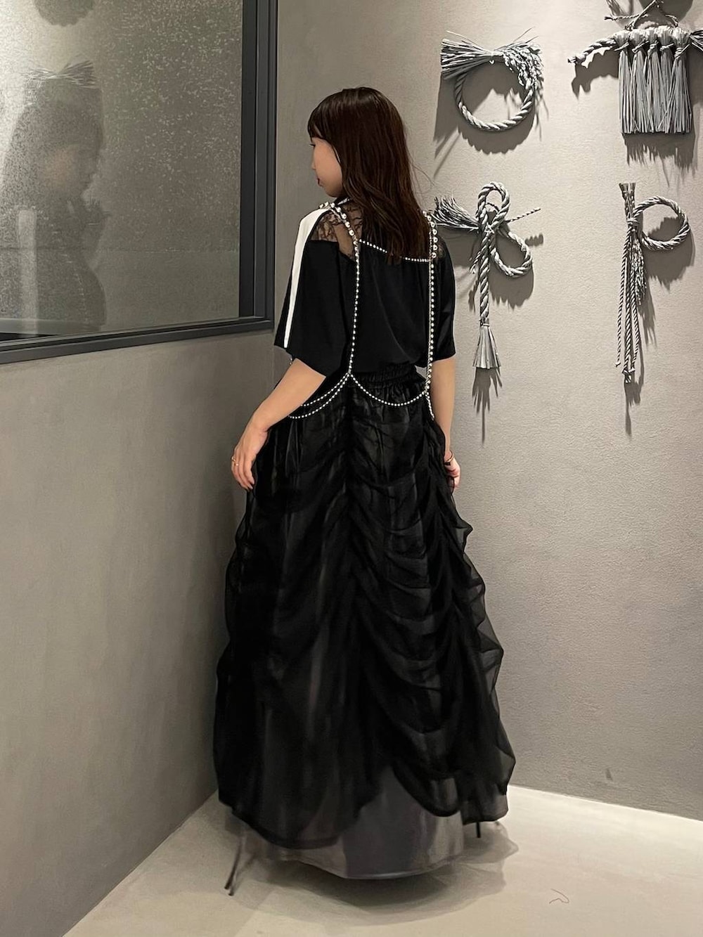 ブラック系のサンダル、シルバー系のサスペンダーを着用したレディースの夏コーディネートの2枚目の写真