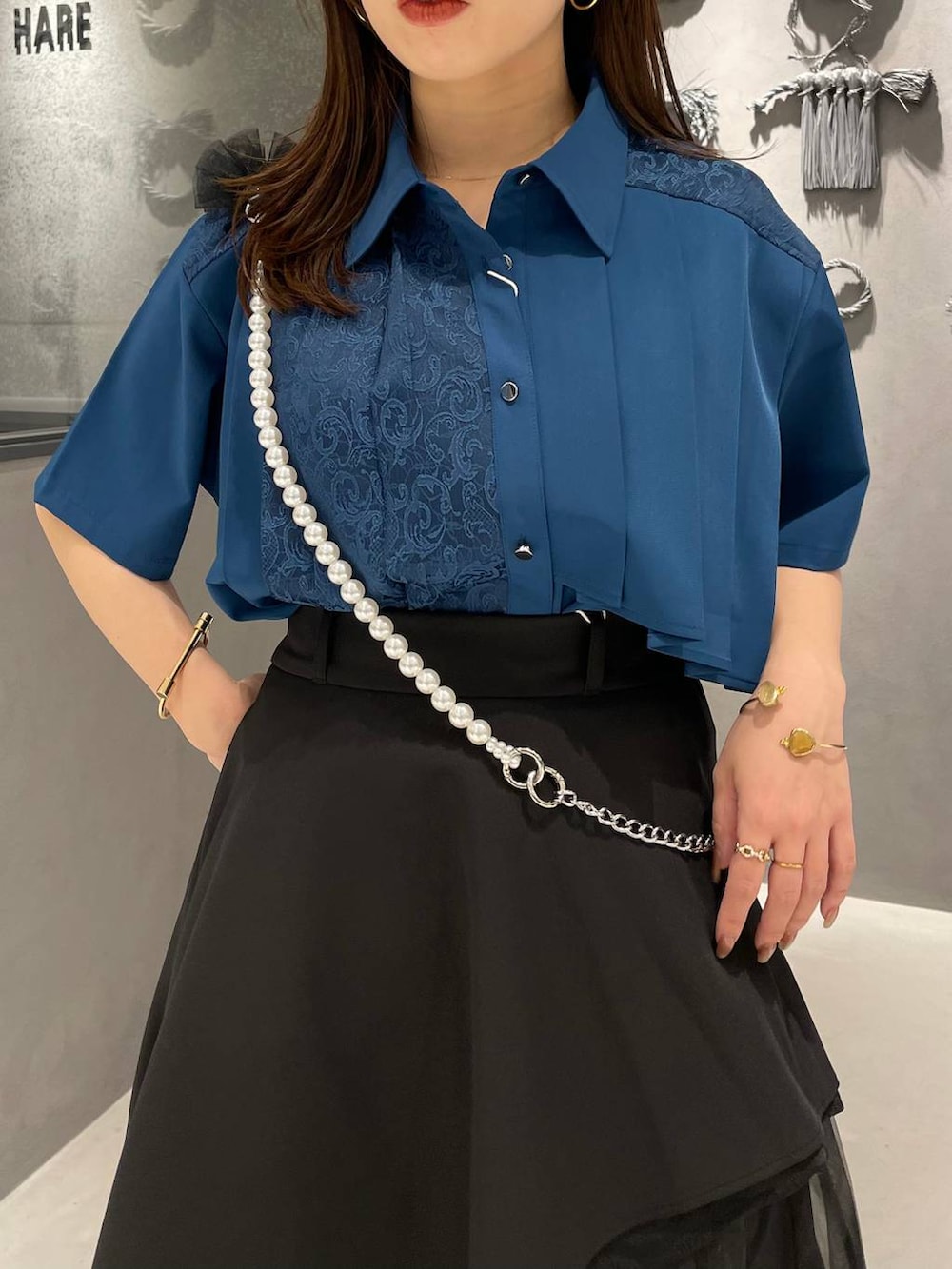 ブルー系のシャツ/ブラウス、ブラック系のスカート、ブラック系のサンダルを着用したレディースの春コーディネートの4枚目の写真