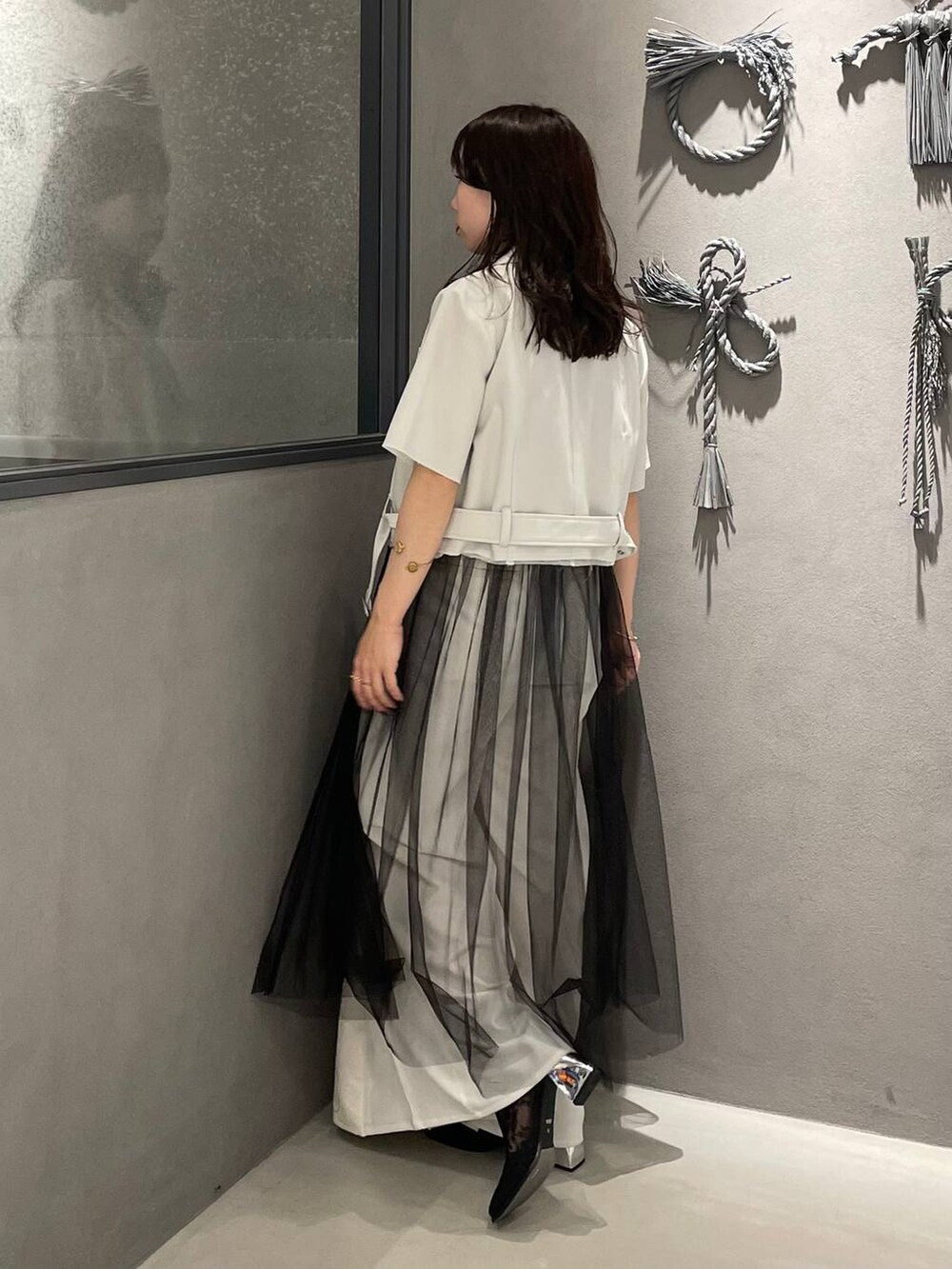 ブラック系のブーツ、ブラック系のタンクトップ、ブラック系のスカートを着用したレディースの夏コーディネートの2枚目の写真