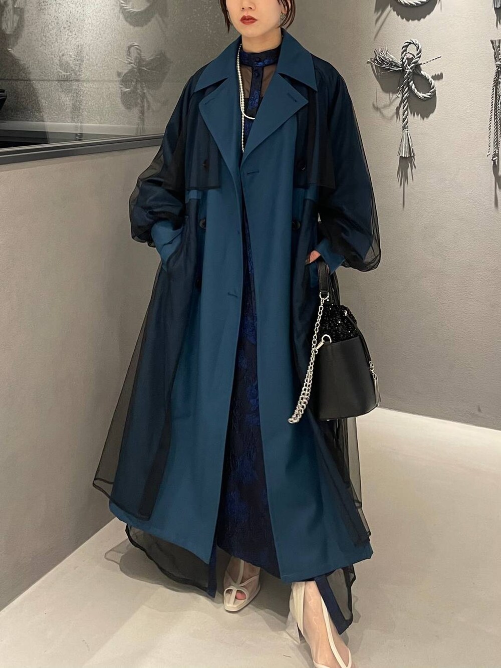 ホワイト系のサンダル、ブルー系のドレス、ブルー系のトレンチコートを着用したレディースの秋コーディネートの3枚目の写真