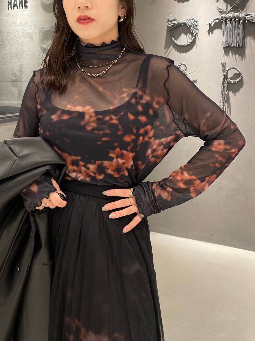 ブラック系のブーツ、オレンジ系のスカート、オレンジ系のTシャツ/カットソーを着用したレディースの秋コーディネートの5枚目の写真