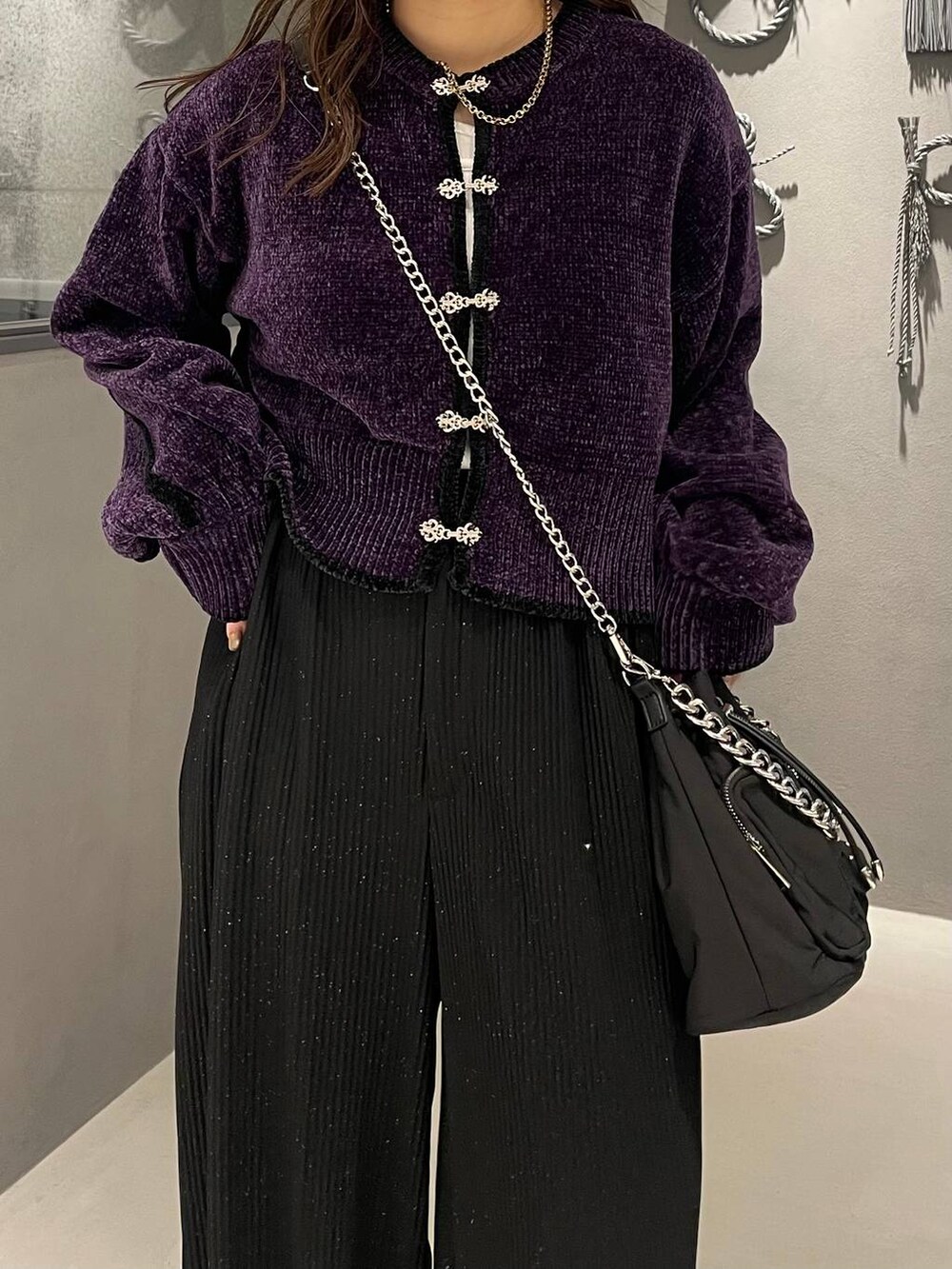 ブラック系のショルダーバッグ、ブラック系のブーツ、パープル系のカーディガン/ボレロを着用したレディースの秋コーディネートの4枚目の写真