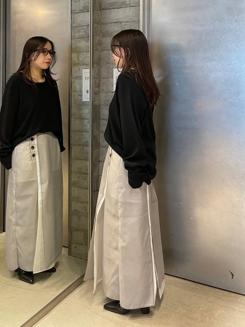 ブラック系のサンダル、ベージュ系のスカート、ブラック系のTシャツ/カットソーを着用したレディースの春コーディネートの2枚目の写真